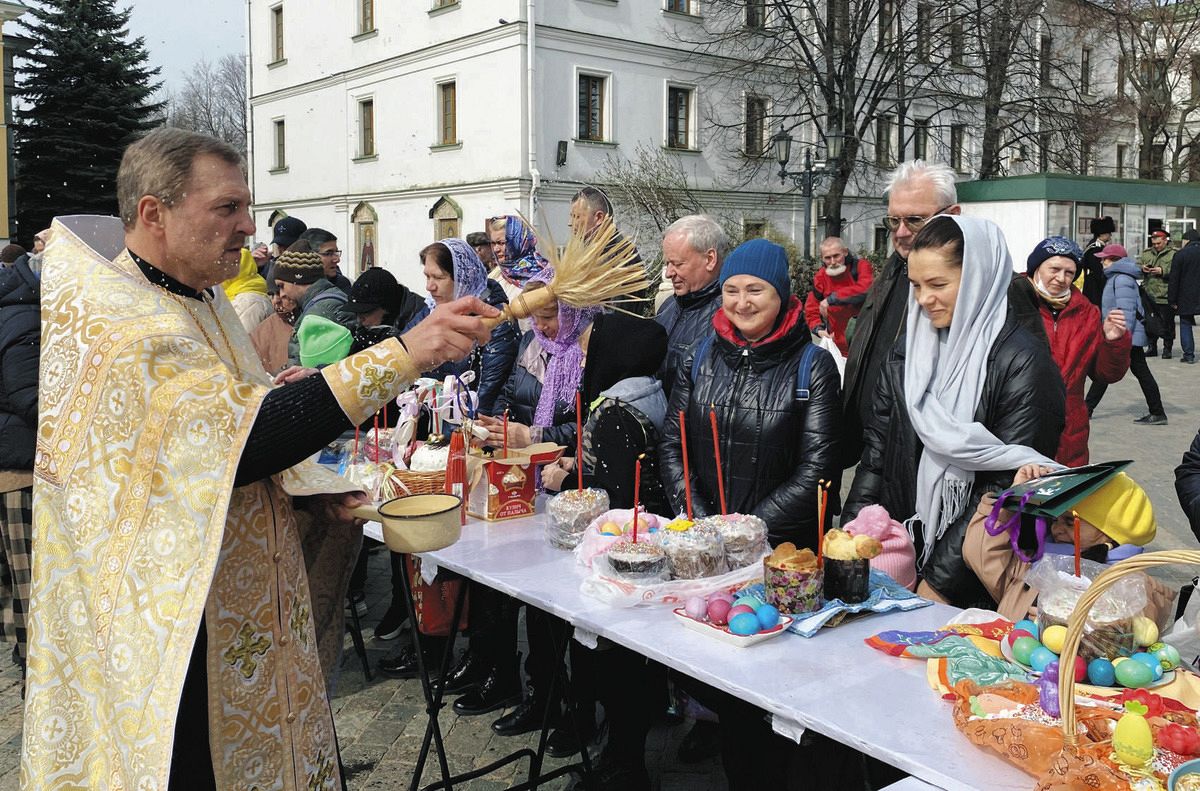 モスクワで4月、復活祭のため信者が持ち込んだパンや卵を聖化するロシア正教会の聖職者（左）