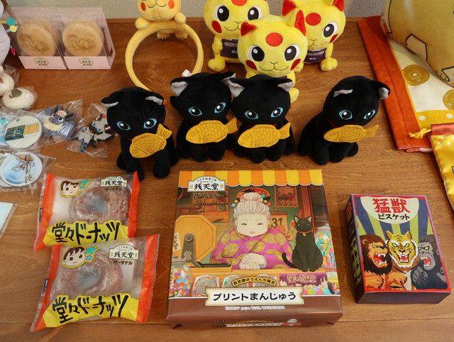 「堂々ドーナッツ」など作品に登場する「ふしぎ駄菓子」やグッズ類も販売される＝埼玉県所沢市で