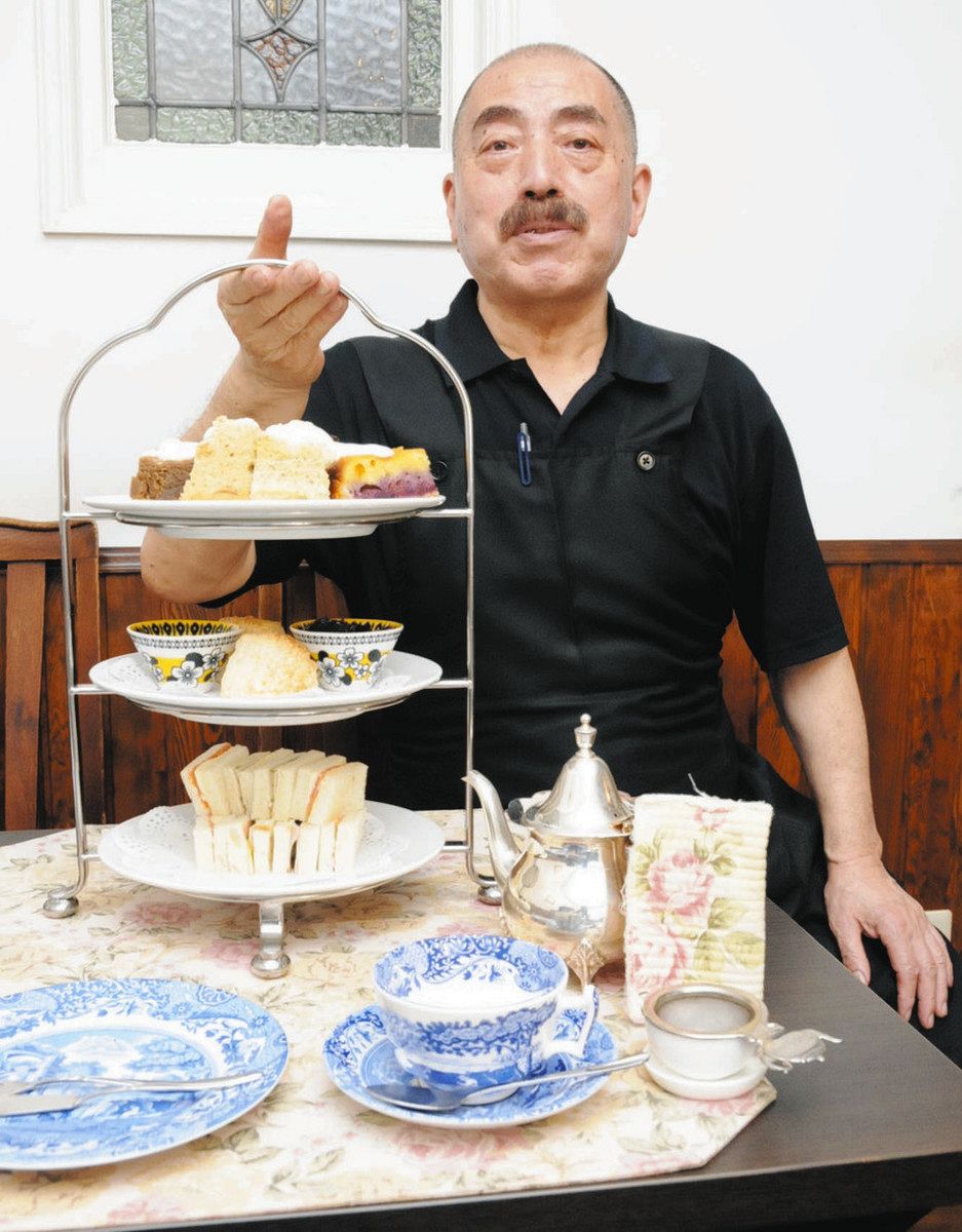 2人前のアフタヌーンティーセットを手に、「ロンドンの定番です」と話す浅利豊作さん＝名古屋市南区で