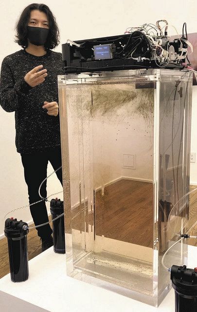 プリンターから水槽にインクを放つ作品を前に思いを語る野村在（ざい）さん＝杉藤貴浩撮影