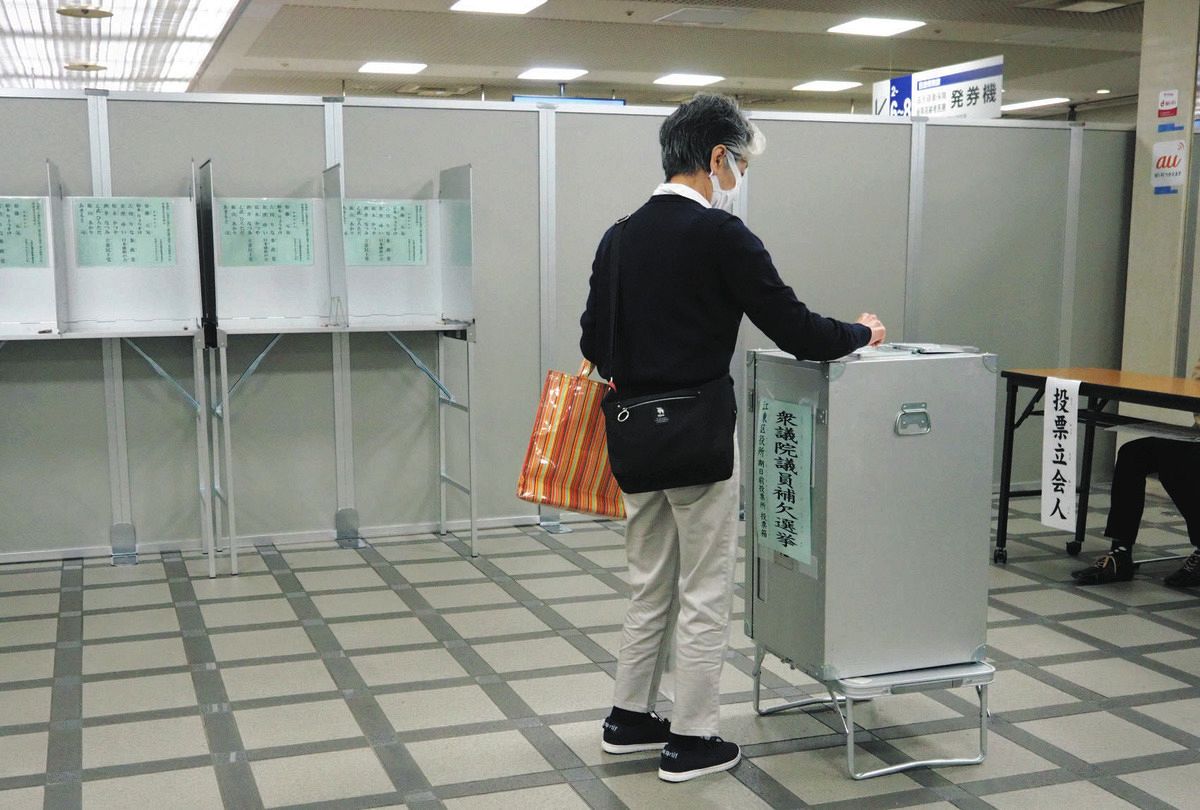 期日前投票所で投票箱に票を投じる有権者＝24日、東京都江東区で