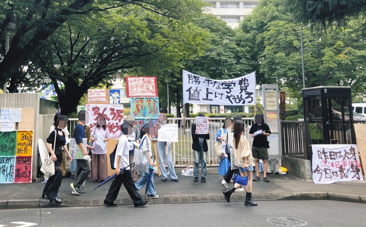 武蔵野美術大前で負担増に反対してビラを配る留学生ら＝東京都小平市で（留学生提供、一部画像処理）