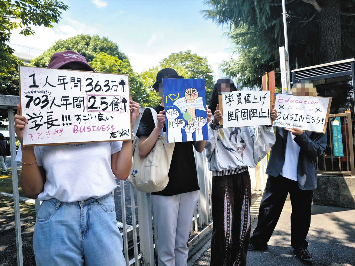 「学費値上げ断固阻止！」とプラカードを掲げ、抗議活動する留学生ら＝東京都小平市の武蔵野美術大前で（留学生提供）