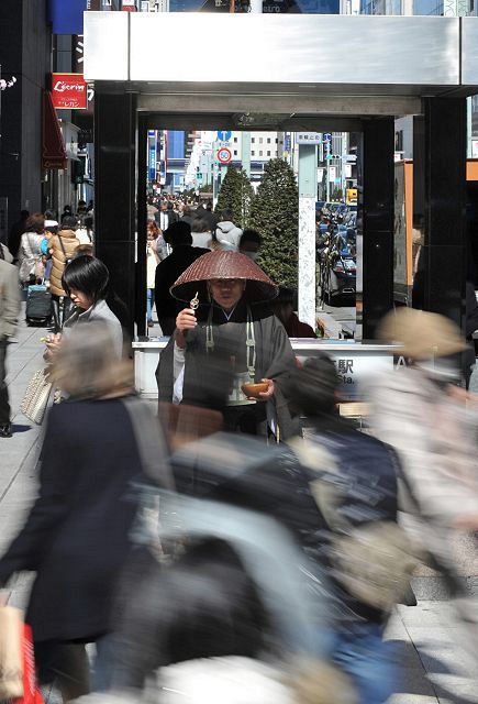 都心の繁華街の一角で托鉢を続ける崇英さん＝2012年3月21日、東京都中央区で