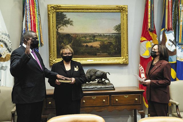 25日、米ホワイトハウスで、ハリス副大統領㊨の立ち会いの下、就任宣誓するオースティン国防長官㊧＝AP