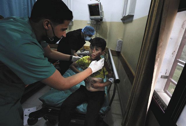 １０日、パレスチナ自治区ガザでの爆発で負傷した少年を治療する医療関係者（ＡＰ）