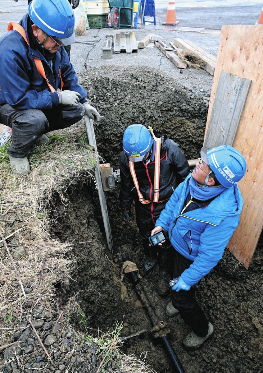 道路を掘って進められる水道管の修理＝8日、石川県輪島市中段町で