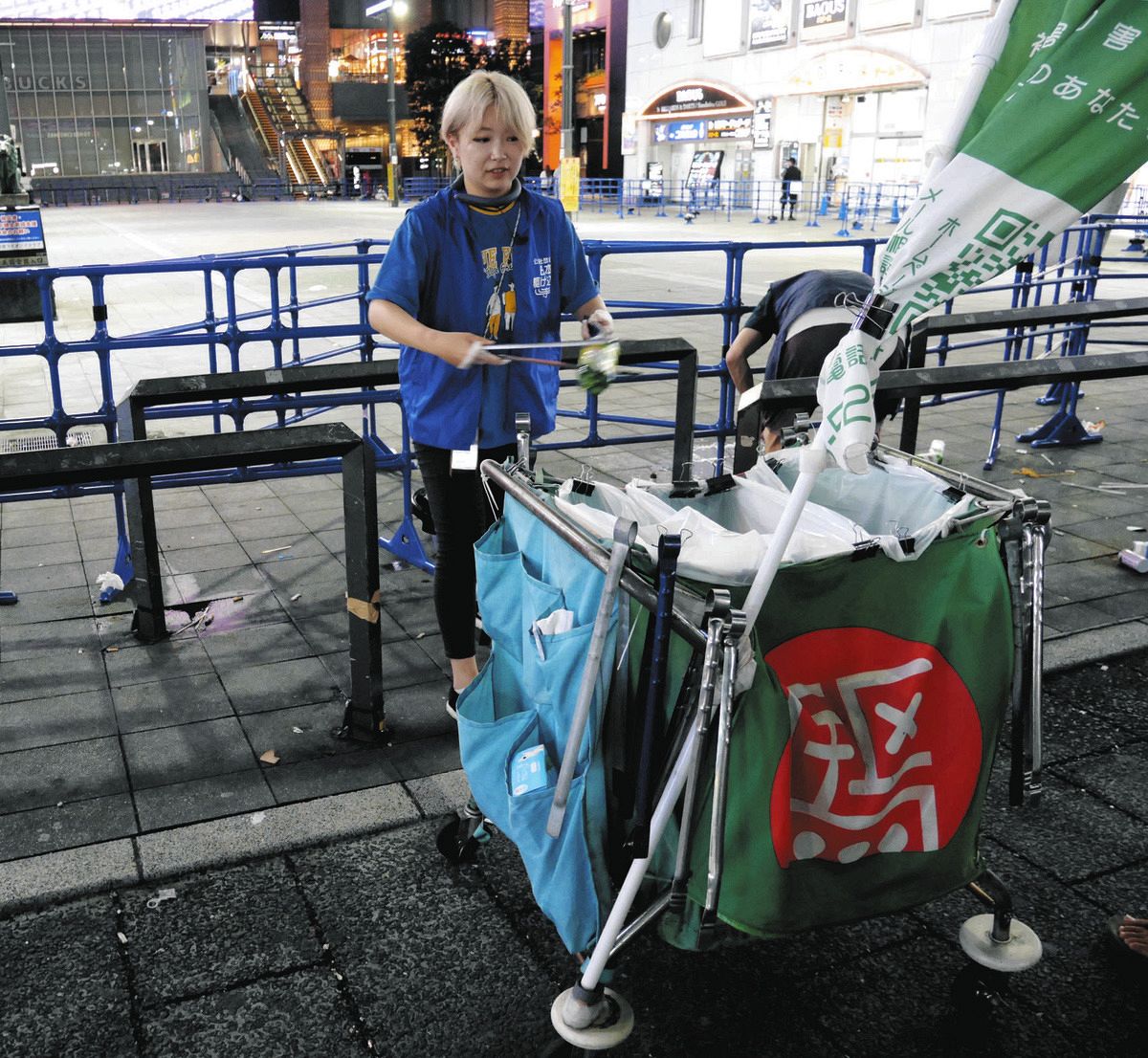 新宿東宝ビル周辺でゴミを拾う清水葵さん（左）ら