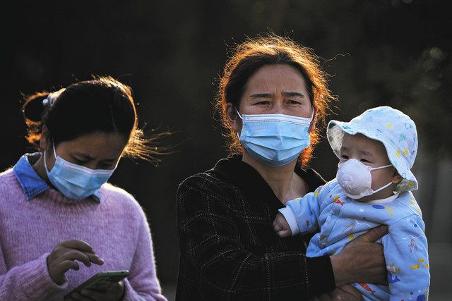 ３日、中国・北京でマスクをして新型コロナウイルスの感染対策をしている親子＝ＡＰ