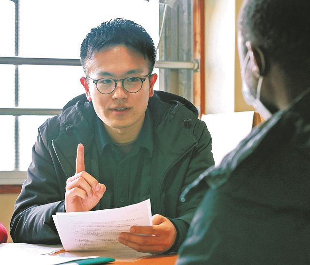 母国での迫害を逃れて来日、その直後にホームレスになった外国人と面談する大沢優真さん（左）（撮影時のみマスクを外しています）＝昨年１２月、東京都中野区で