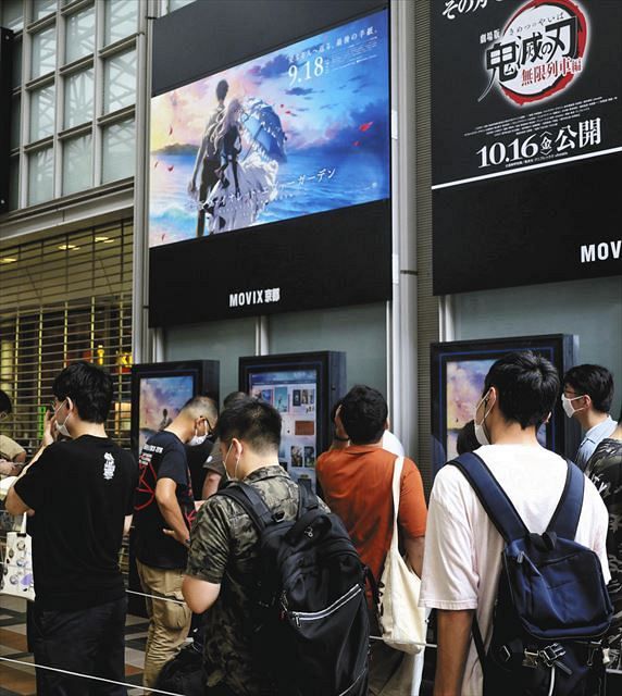 「劇場版　ヴァイオレット・エヴァーガーデン」が上映される映画館前に並ぶ人たち＝１８日午前、京都市で（共同）