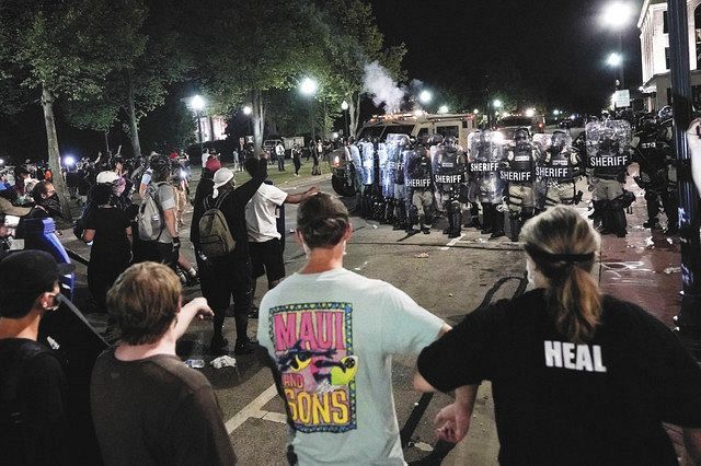 ２４日、米ウィスコンシン州ケノーシャで、警官隊と衝突するデモ参加者たち＝ＡＰ