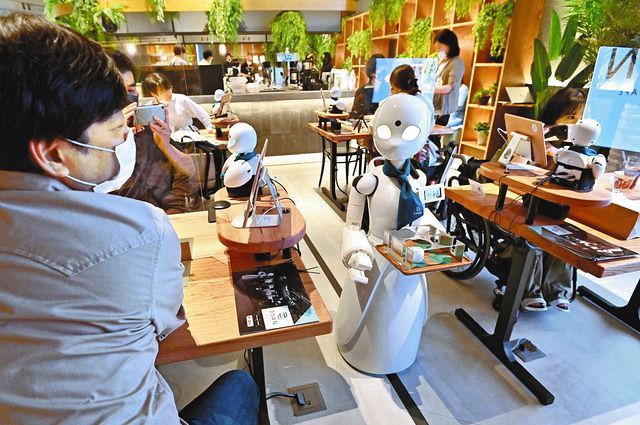 テーブルの上で遠隔操作で注文を聞いたり、店内を移動して商品を運んだりする分身ロボット＝２１日、東京都中央区で