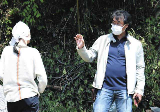 農作業中のオリガさん（左）を励ます木村准教授＝福島県二本松市で