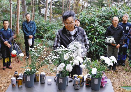 防災ヘリの墜落事故現場で献花する遺族の田村富司さん（中央）＝中之条町で