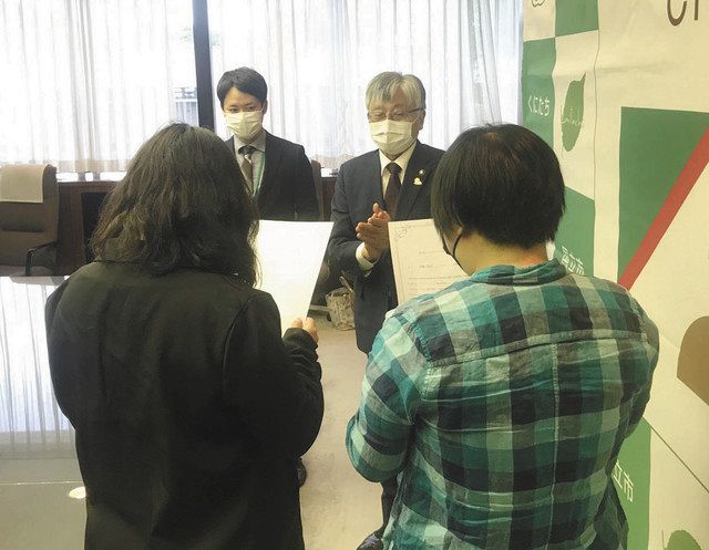 証明書を受け取った市内在住のカップル（手前）＝国立市役所で 