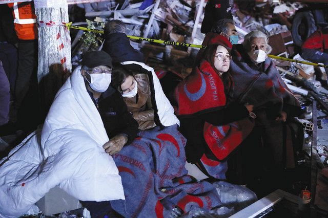 ３１日、トルコ・イズミルで、余震を恐れ、瓦礫が散乱する屋外ですごし、救出活動を見守る地元の人たち＝ＡＰ