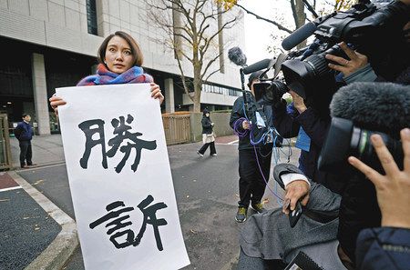 性暴力被害を巡る訴訟の判決後、東京地裁前で「勝訴」と書かれた紙を掲げるジャーナリストの伊藤詩織さん＝１８日午前