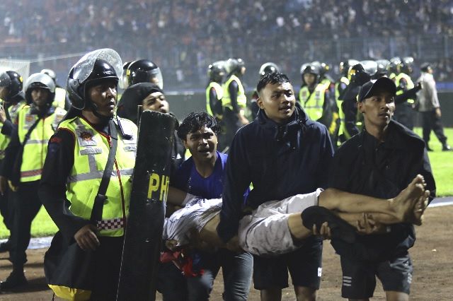 1日夜、負傷者がサッカー場から運び出される＝AP