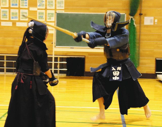 少年剣士に面を打ち込む田中さん（右） 