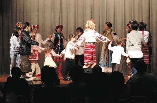 Ukrainian performers perform folk dances in a circle with visitors on stage at the Civic Center in Chiba's Chuo Ward.
