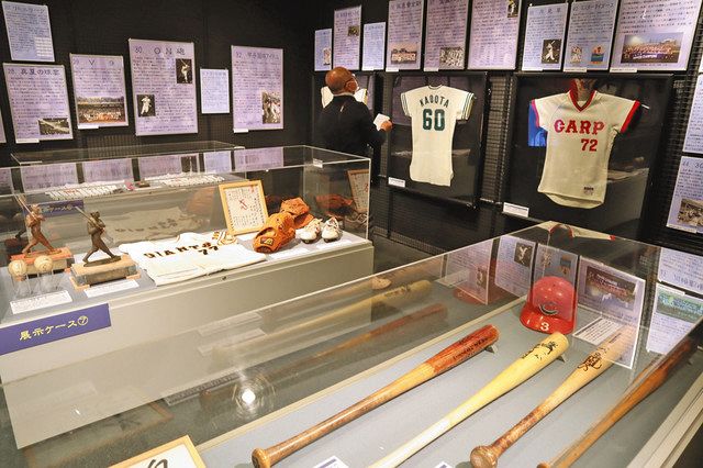 日本の野球史を物語るバットやユニホームなどが並ぶ展示＝文京区で