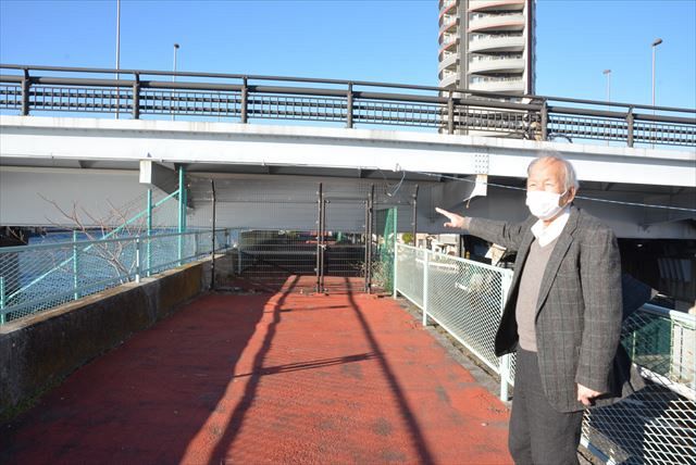 小松川橋・新小松川橋と交差する堤防を視察する関口孟利さん。歩道はフェンスで遮られている＝東京都江戸川区で