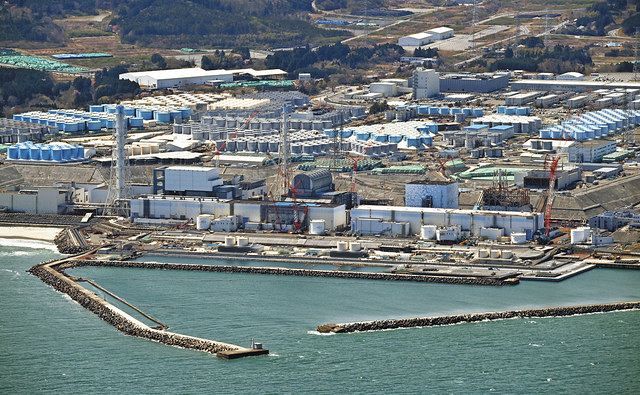 事故収束作業が進む福島第一原発の原子炉建屋。奥には処理水のタンクが並ぶ＝１０日、福島県で、本社ヘリ「おおづる」から（戸田泰雅撮影）