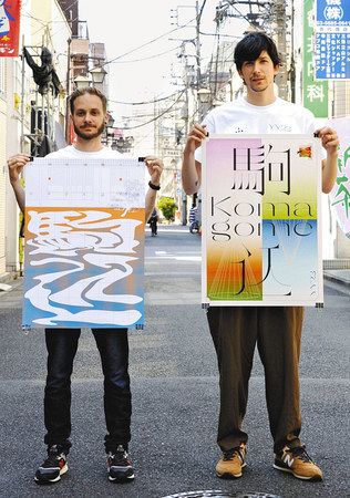 駒込駅をテーマにしたポスターを持つジュリアン・ウルフさん（左）とジュリアン・メルシエさん＝都内で