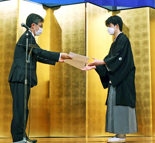 日本将棋連盟の佐藤康光会長（左）から贈位状を授与される藤井聡太五冠