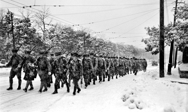 雪降る中、日比谷公園付近を行進する鎮圧部隊

＝１９３６（昭和１１）年２月２６日から２９日までの間のいずれか
