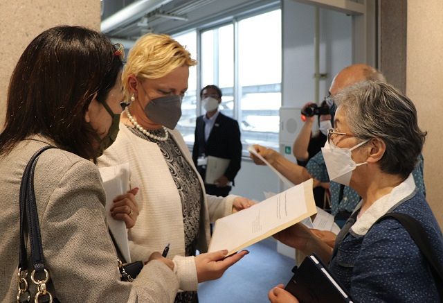 国連科学委員会のメットカーフ事務局長（左から２人目）に、甲状腺がんに多くの子どもたちが苦しむ実態を訴える文書を手渡す千葉親子さん㊨＝福島市で