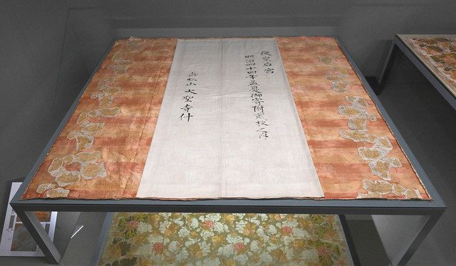 大礼服の裏地に由来が記載された墨書。２枚に裁断されたトレインの上半分＝明治神宮ミュージアムで