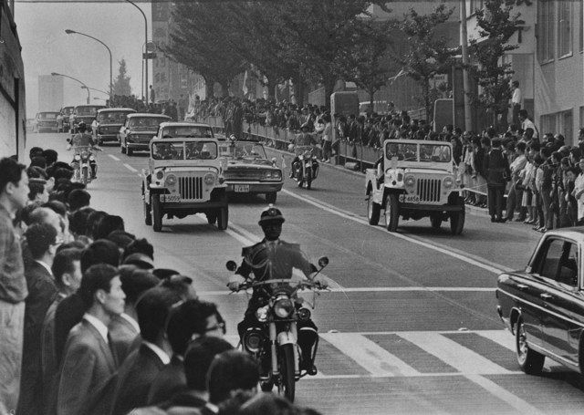 ﻿東京都内を行く葬列。道路脇で多くの都民が見送る＝1967年10月31日、東京・渋谷近くで 