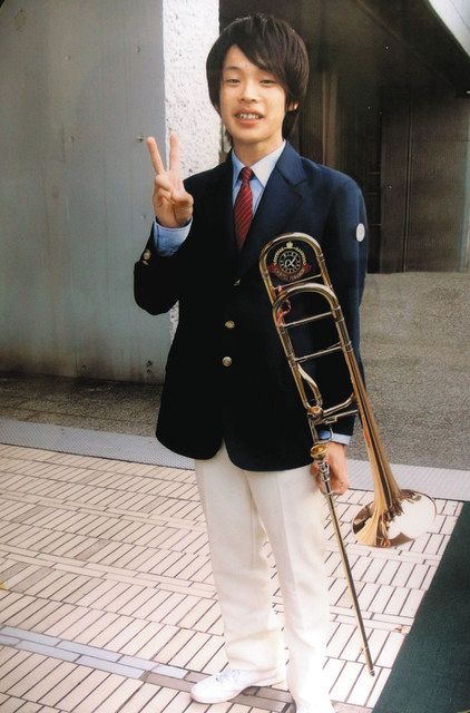 高校１年の時、トロンボーンを手に笑顔を見せる浅野大義さん＝千葉市中央区で（浅野さんの祖父・忠義さん提供）
