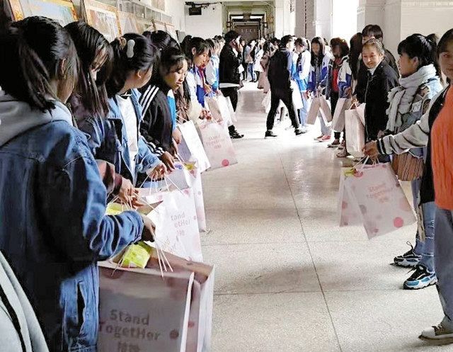 中国四川省涼山イ族自治州昭覚県の中・高校で昨年１０月、生理用品の入った紙袋を手にする生徒ら＝彭さん提供