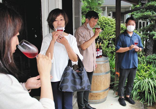 山田さん（右）が手がけた「純川崎産」のワインを味わう参加者たち
