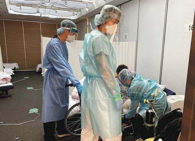 患者を車いすに乗せようとする看護師ら＝いずれも１６日、横浜市中区のかながわ緊急酸素投与センターで（代表撮影）