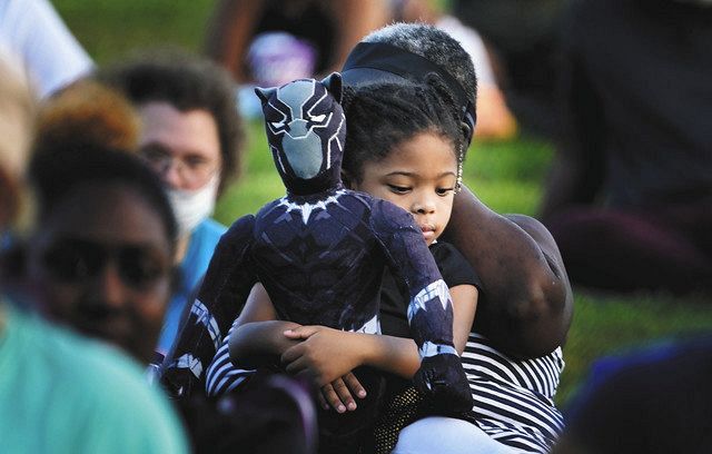 高チャドウィックボーズマン氏の故郷アメリカサウスカロライナ州アンダーソン3日に開かれた上映会など追悼行事で代表作「ブラックパンサー」の人形を抱えている少女= AP