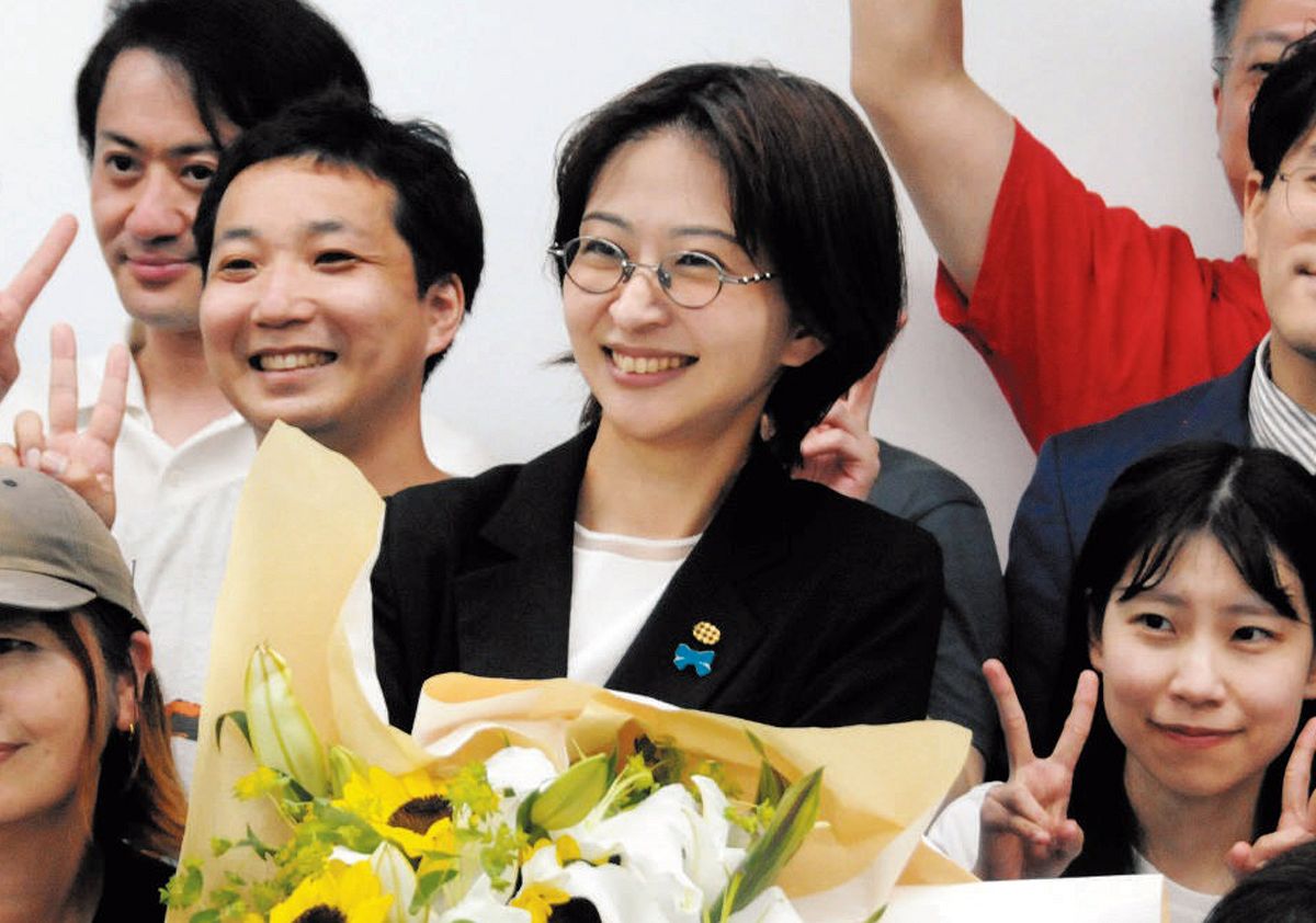 当選が確実になり花束を手に笑顔を見せる佐藤沙織里さん（中央）＝6月22日、東京都千代田区で(山口登史撮影)