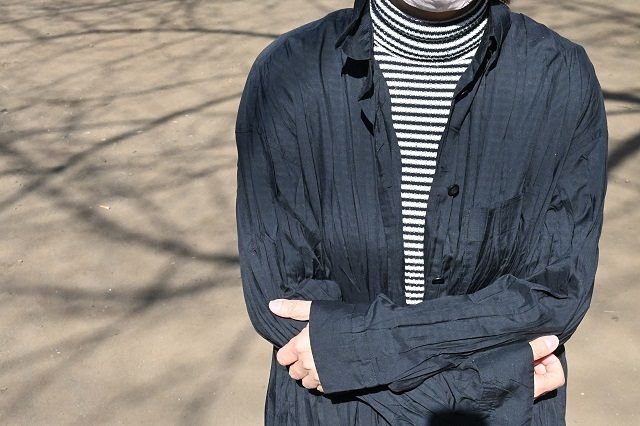 弁当の配布活動もする公園で取材に応じる芹沢さん。30年来の黒いシャツなど愛用の服をいくつも持ってきてくれた