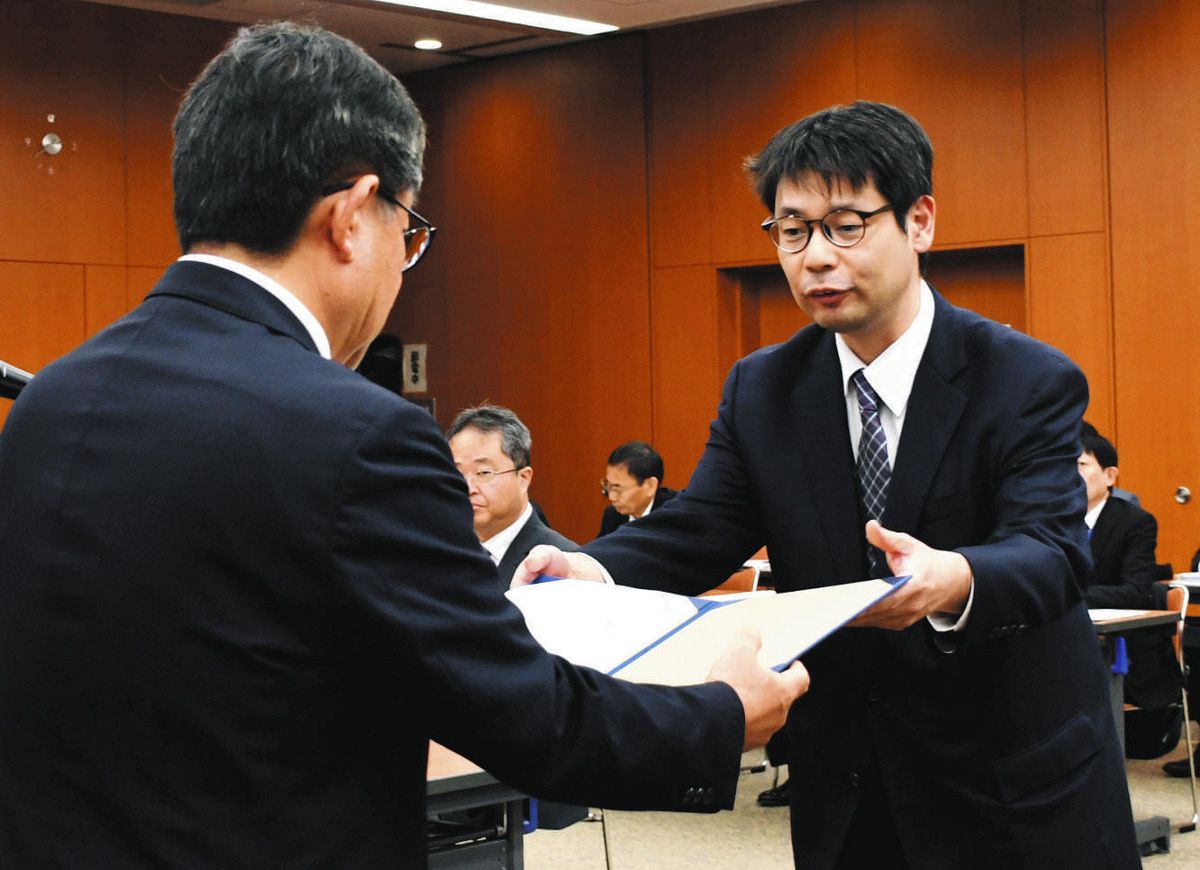 越川信一市長（左）から諮問書を受け取る矢尾板俊平委員長