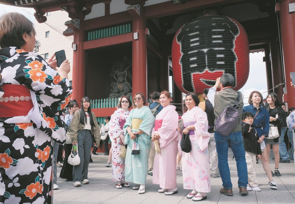 雷門前で記念写真を撮る外国人観光客=2日、東京・浅草で