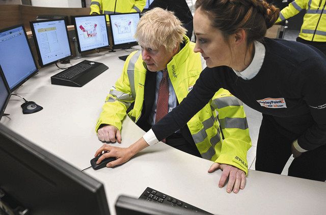 ７日、英南西部のヒンクリーポイントＣ原発で、コントロールセンターを視察するジョンソン首相（右）＝ＡＰ