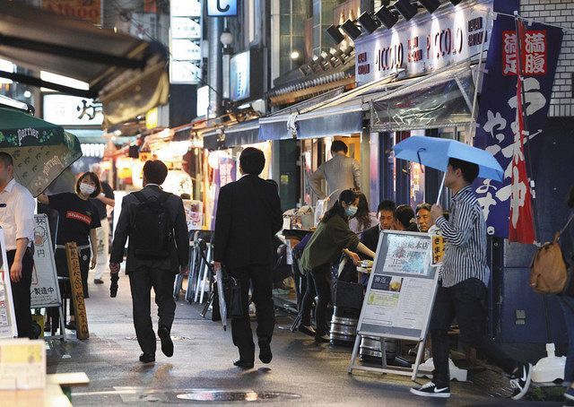 新橋の飲食店街を行き交う人たち＝２６日、東京都港区で