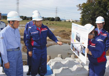 決壊した堤防の復旧作業の状況を聞く菅官房長官（左）＝東松山市で