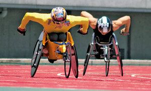 レーサーと呼ばれる競技用の車いすで疾走する、レース時の廣道純さん（左）＝２０１４年の日本選手権で