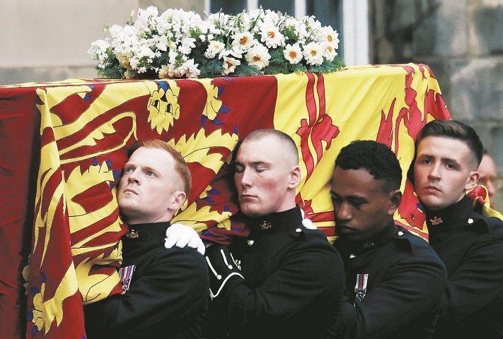 11日、英北部エディンバラでホリールード宮殿にエリザベス女王の棺を運び入れる担ぎ手ら＝AP
