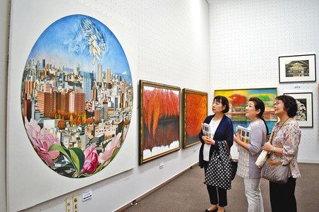 極美大賞に輝いた城戸真亜子さんの油彩画「窓辺には花を」を鑑賞する来場者＝いずれも台東区で