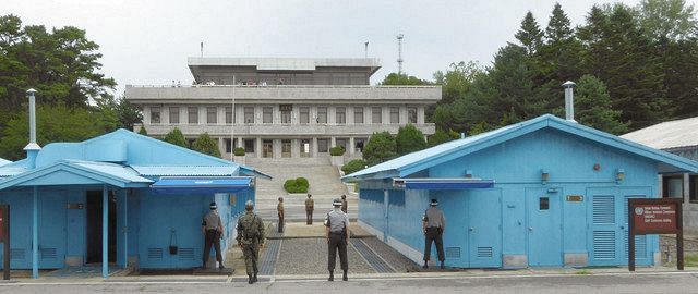 南北軍事境界線に位置する板門店で向き合う北朝鮮兵士（奥３人）と韓国軍兵士。奥は北朝鮮の建物